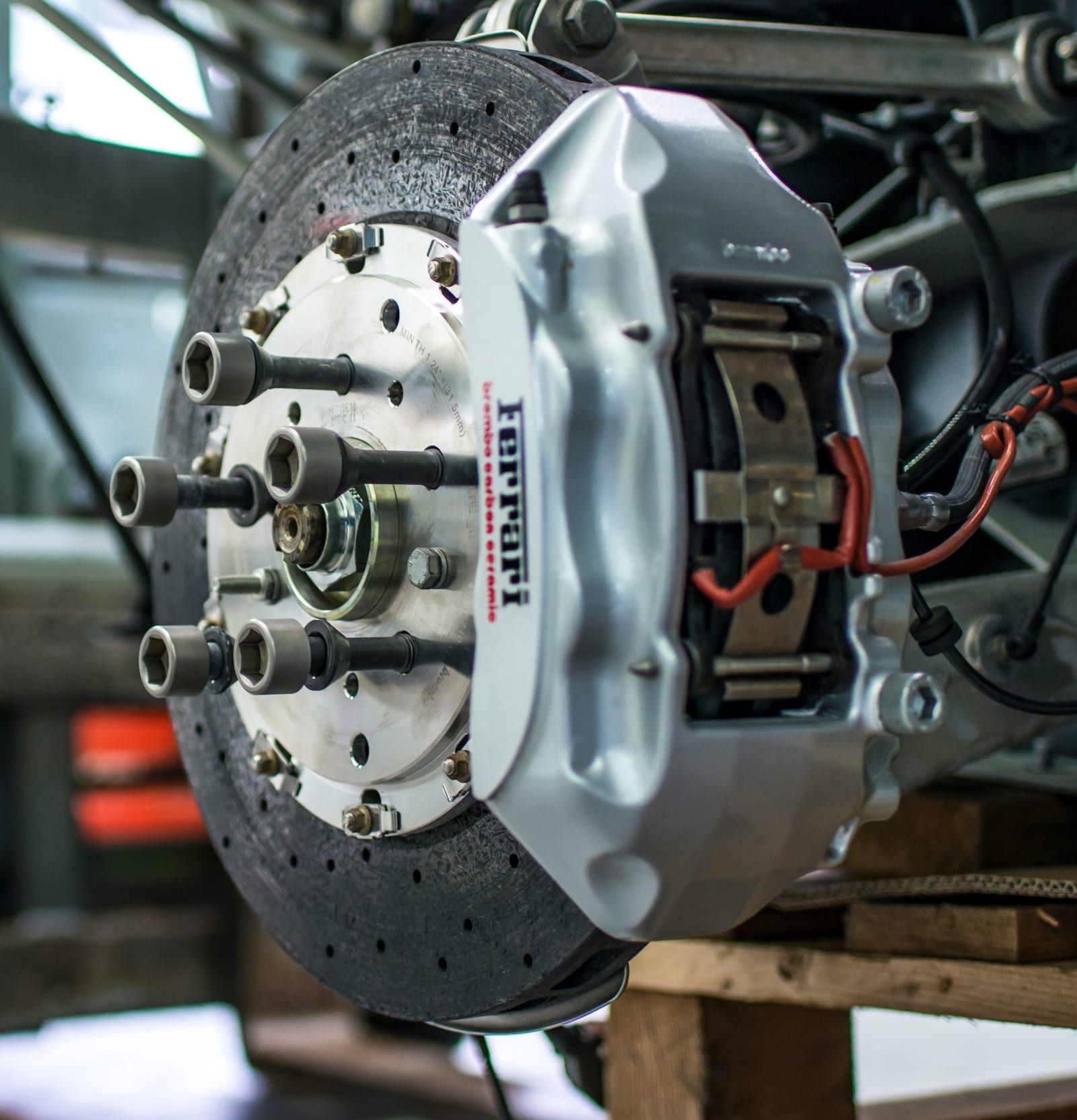 Brake disc and Ferrari caliper on a car raised in a workshop