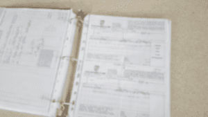 Thick binder of paper maintenance records, blurred
