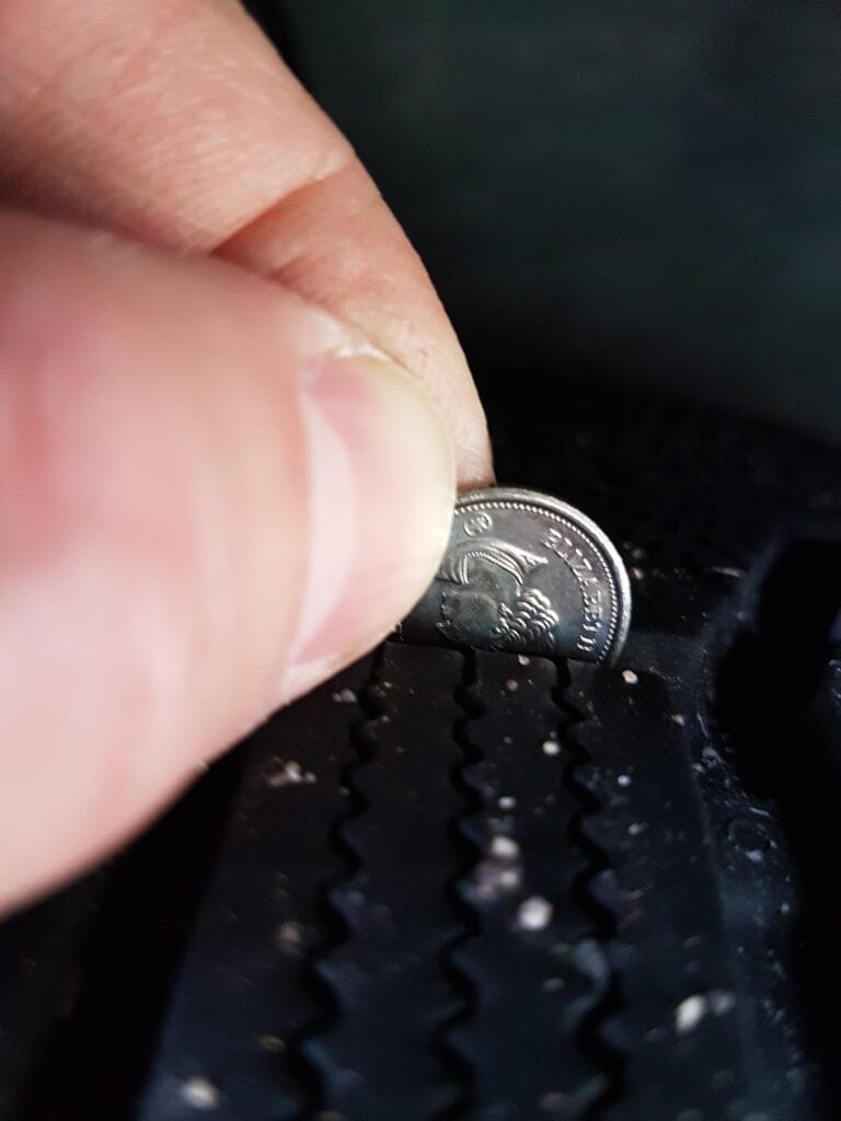 Coin pushed into a tire’s tread to check its depth