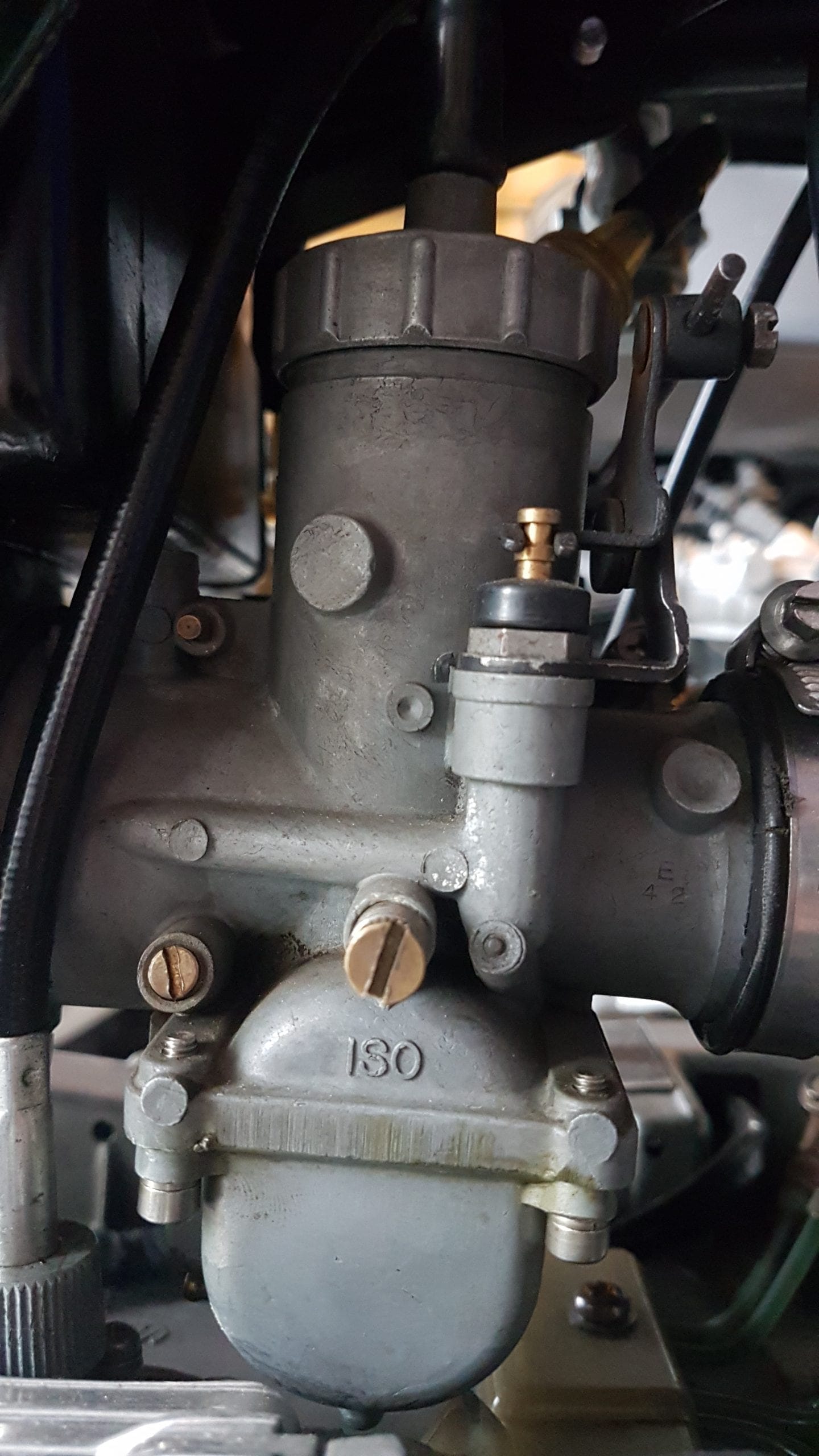 Close-up of a carburetor mounted on an engine