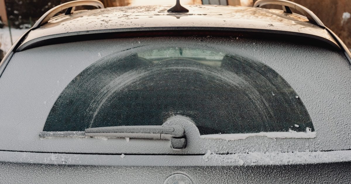 Frost-covered rear window and wiper of a car