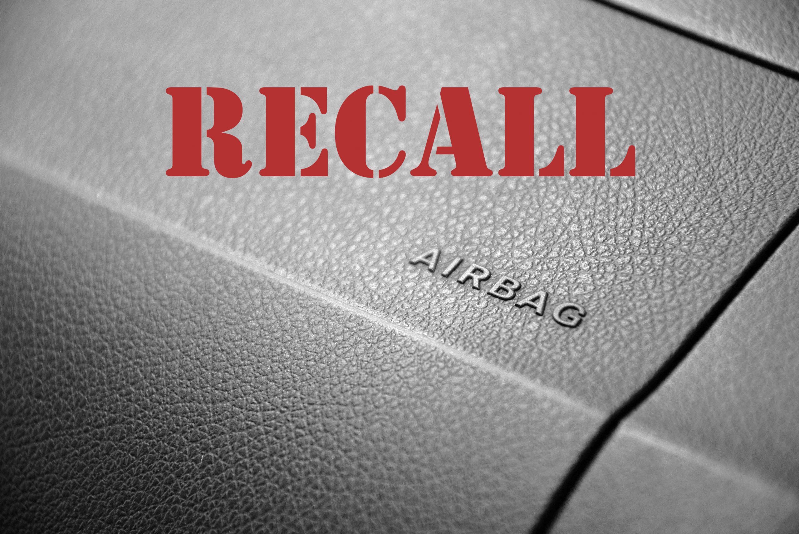 Vehicle recall word on top of image of dash with airbag letters on it