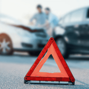 Emergency triangle with drivers exchanging information in background