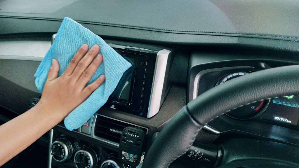 hand wiping the interior of a car