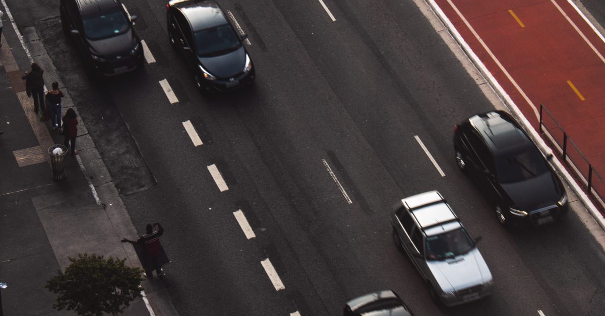 A multi-lane highway from above with cars driving in their lanes.