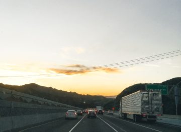 Looking out the front window of a car driving on a highway in low light.