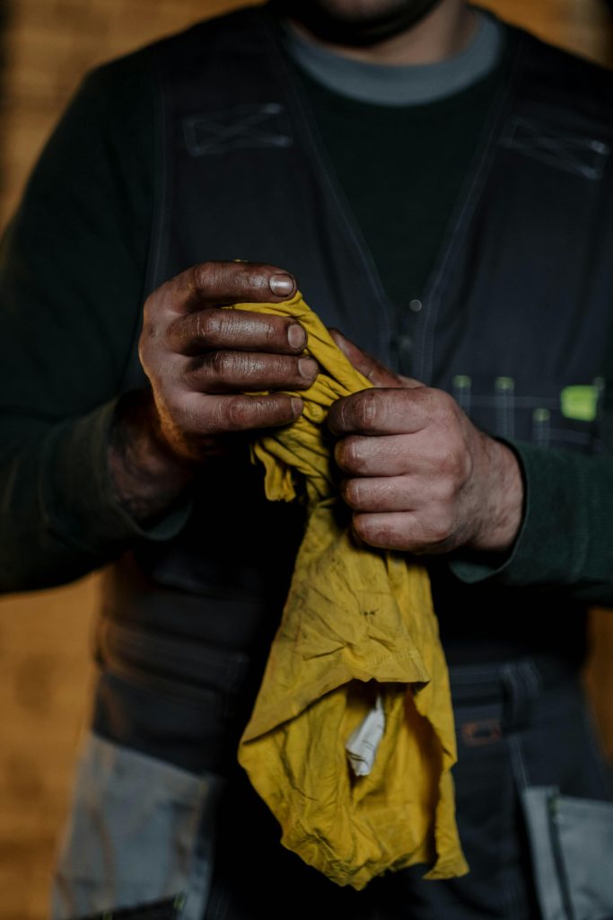 Mechanic's oily hands holding a rag