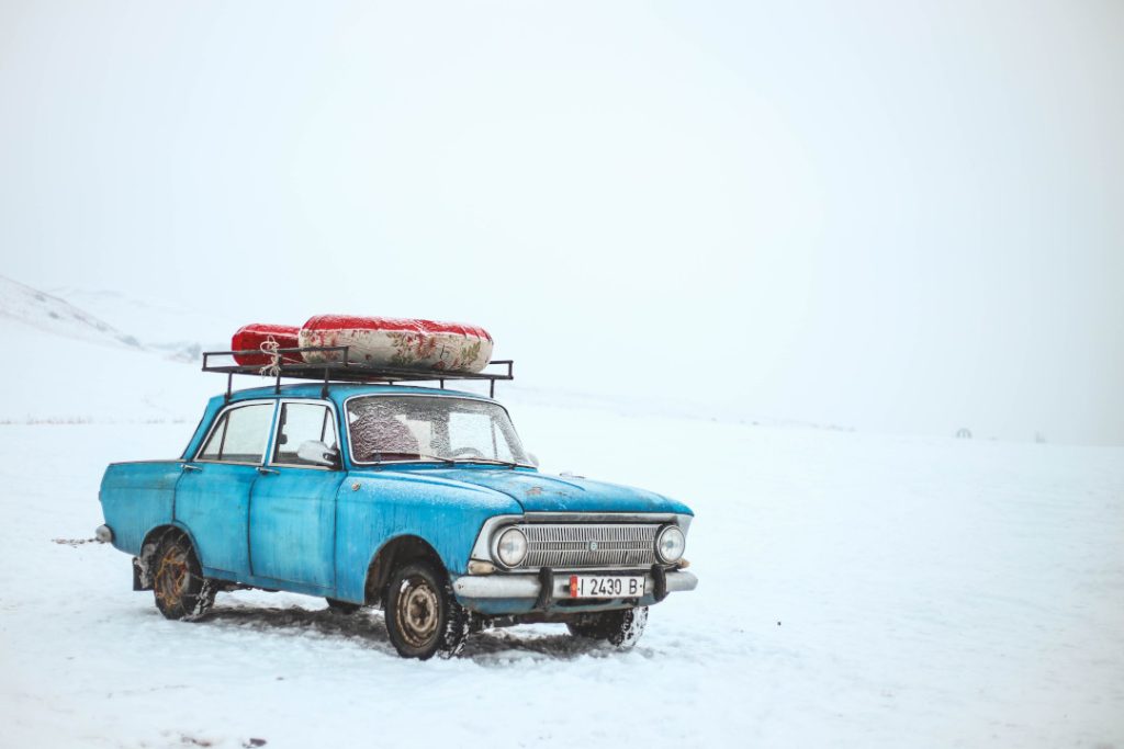 old car in a desolate snowy environment