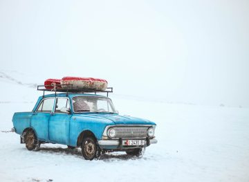 old car in a desolate snowy environment